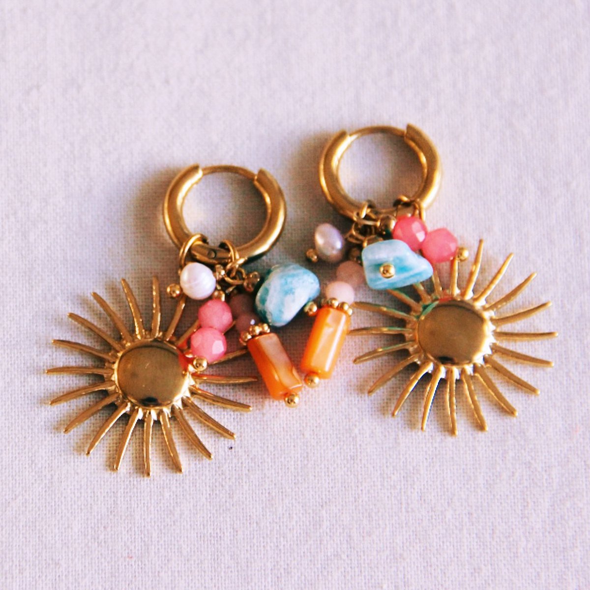 Ohrring mit Cluster von Edelsteinen und Sonne